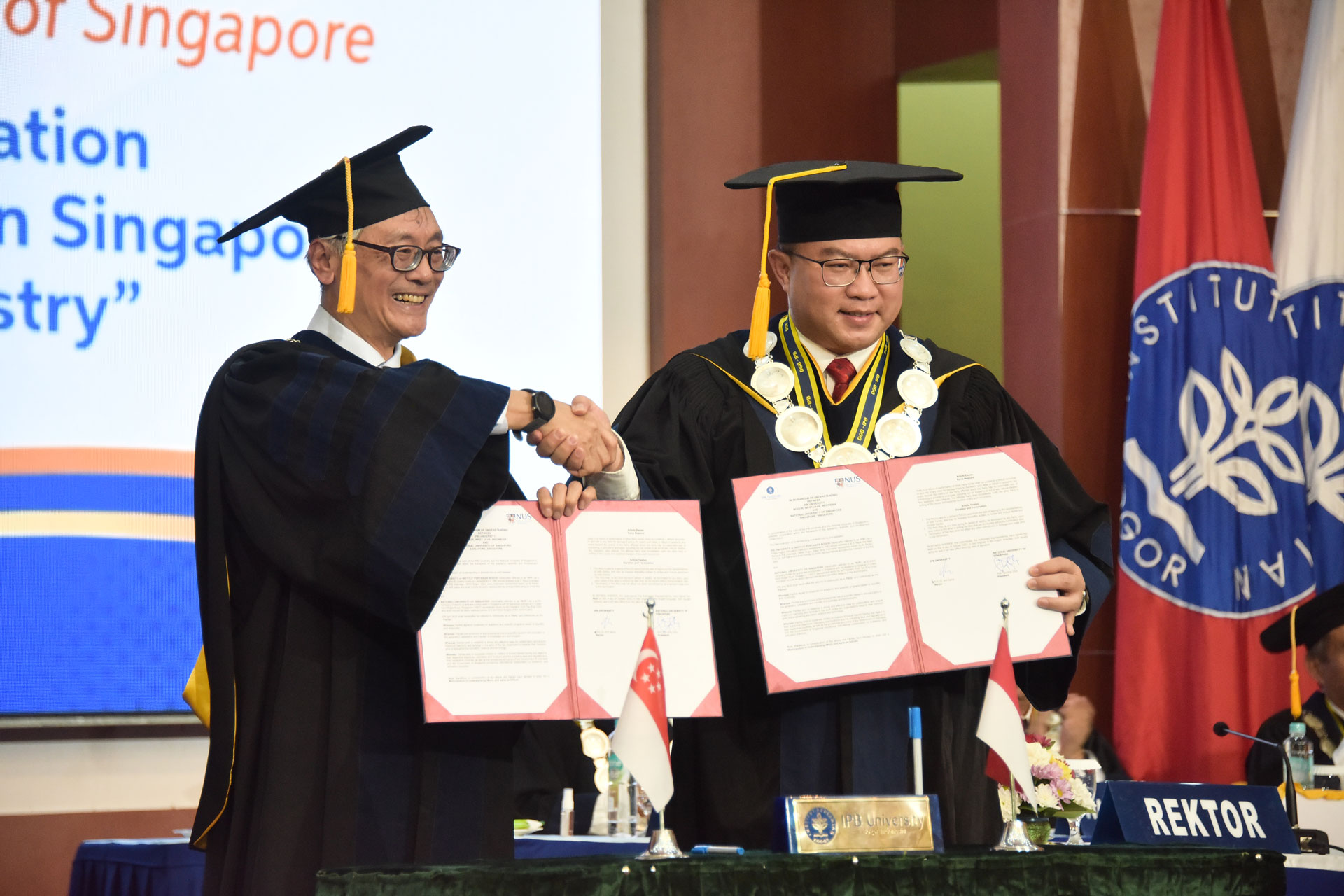 NUS President, Professor Tan Eng Chye (left) and Rektor of IPB University, Professor Arif Satria showing the signed MoU. 