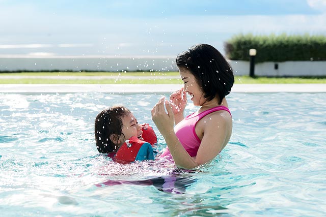 happy-asian-mother-and-daughter-having-fun-in-hotel-swimming-pool